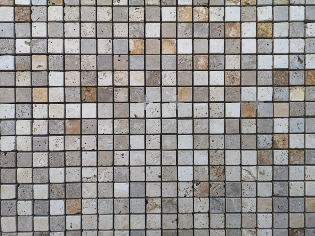Detailed view of a geometric mosaic tile wall featuring a neutral color palette.